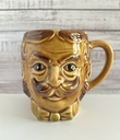 Tasse brune à moustache représentant une tête d'homme