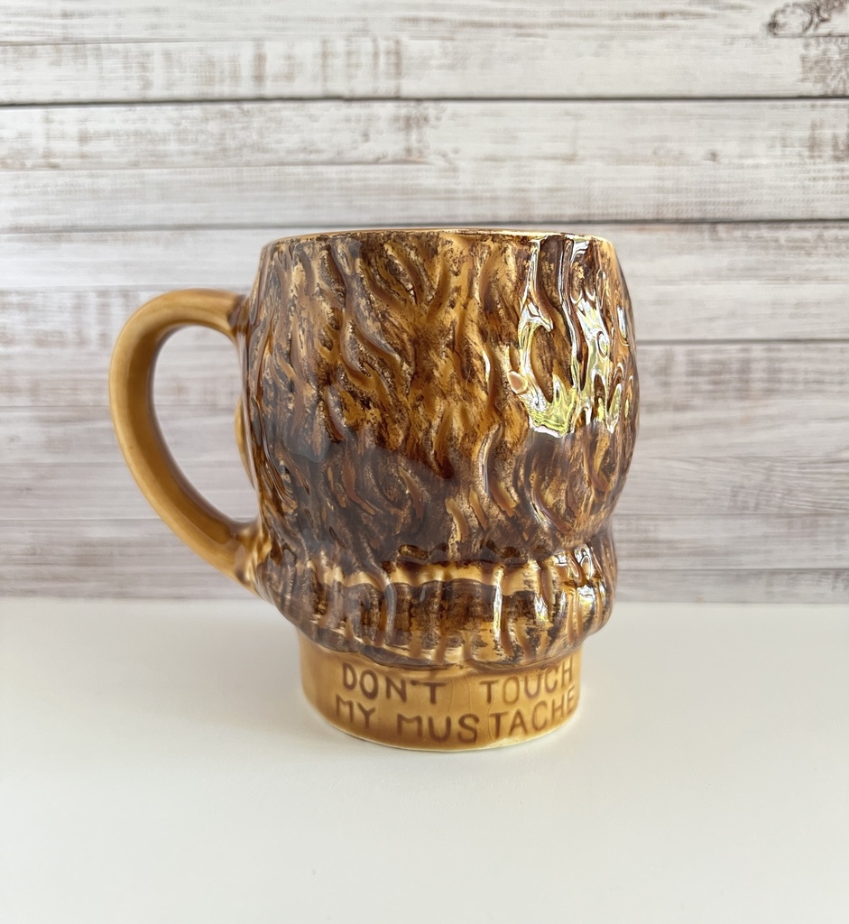 Tasse brune à moustache représentant une tête d'homme
