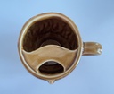 Tasse brune à moustache représentant une tête d'homme
