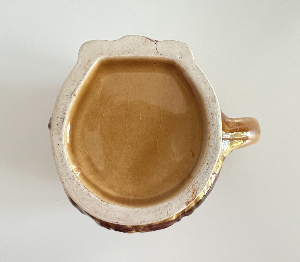 Tasse brune à moustache représentant une tête d'homme