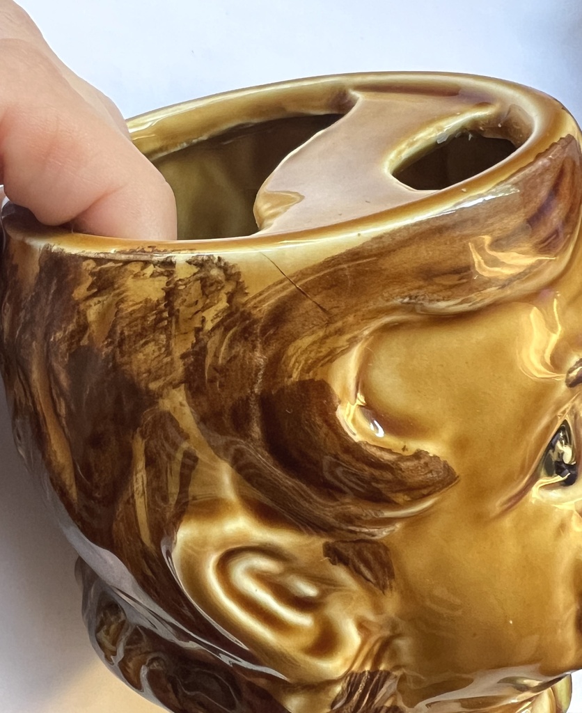 Tasse brune à moustache représentant une tête d'homme