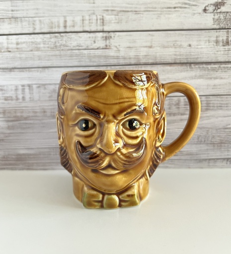 Tasse brune à moustache représentant une tête d'homme
